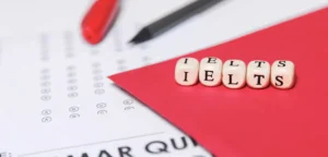 Gambar dadu bertuliskan IELTS di atas sebuah paper test